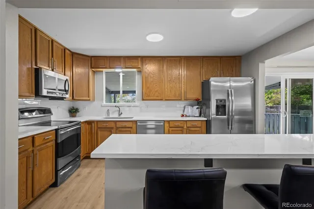 a kitchen with stainless steel appliances granite countertop a sink stove and refrigerator