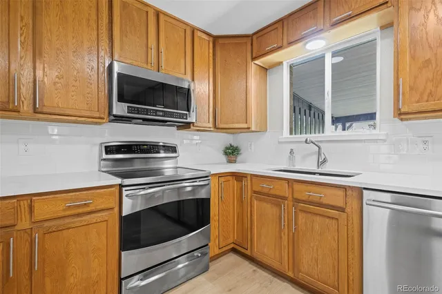 a kitchen with stainless steel appliances granite countertop a stove microwave and sink