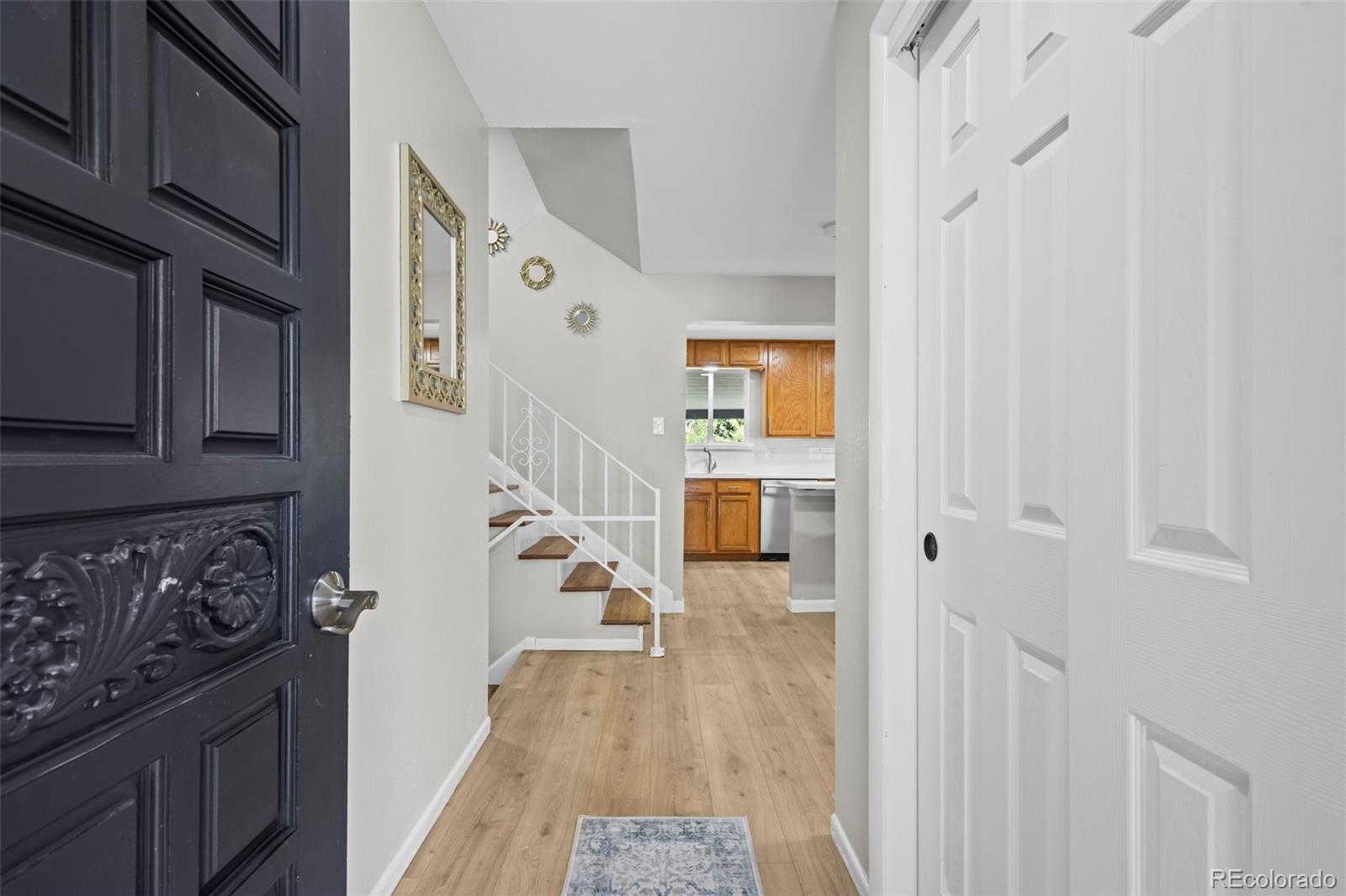390 Scranton Street Aurora, CO 80011 - Photo 6 of 45 a hallway with wooden cabinets and a stove top oven