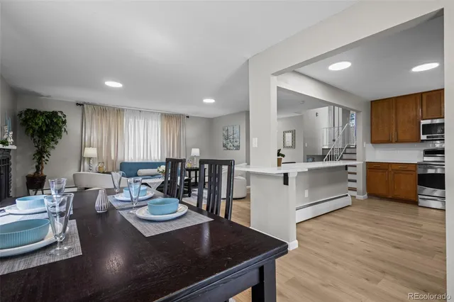 a large kitchen with a table chairs sink and white cabinets