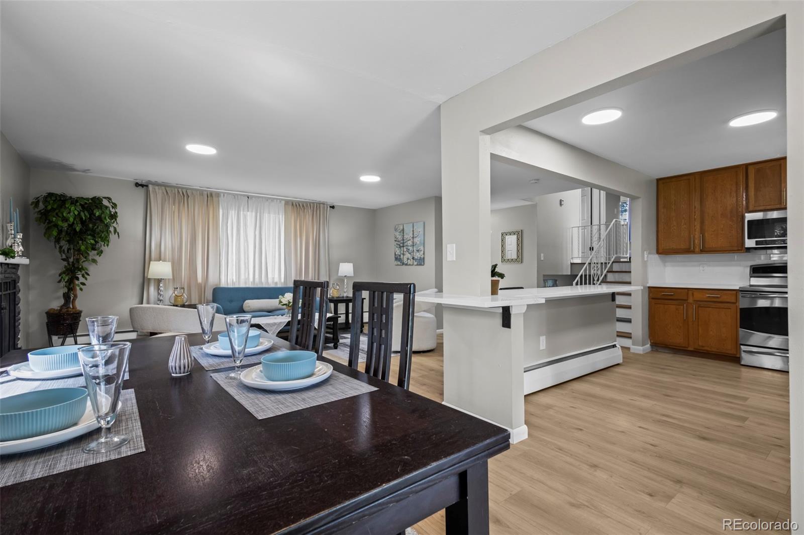 390 Scranton Street Aurora, CO 80011 - Photo 8 of 45 a large kitchen with a table chairs sink and white cabinets