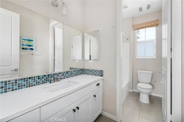 a bathroom with a sink a toilet and a window