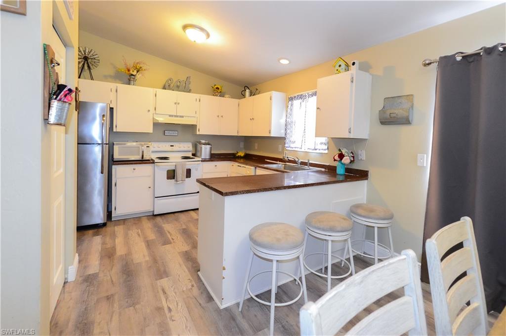 18347 Fuchsia Road Fort Myers, FL 33967 - Photo 12 of 35 a kitchen with a sink a stove a refrigerator and wooden cabinets