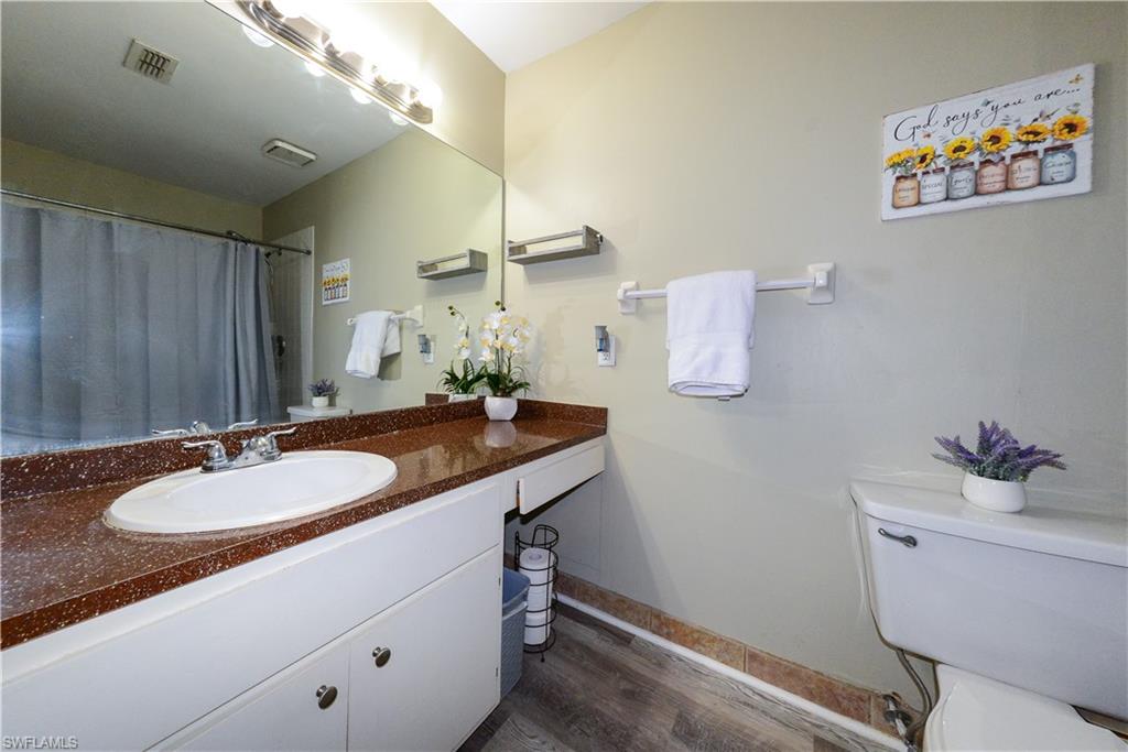18347 Fuchsia Road Fort Myers, FL 33967 - Photo 9 of 35 a bathroom with a granite countertop sink a mirror and a toilet