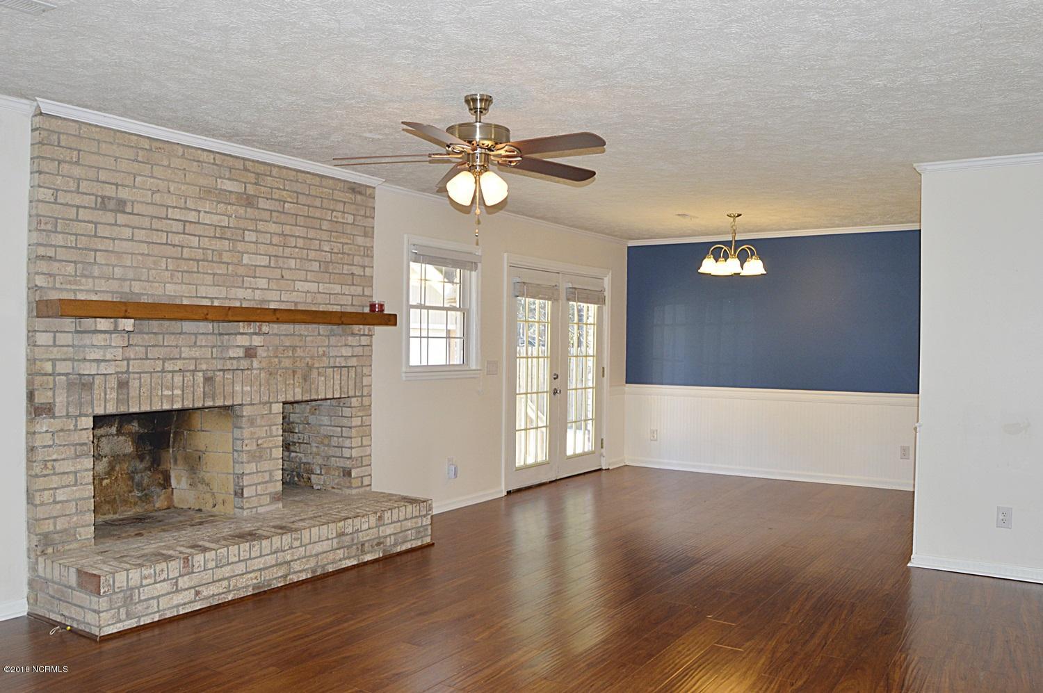 313 North Hampton Road Wilmington, NC 28409 - Photo 2 of 22 Welcoming Living/Dining with beautiful wood-burning fireplace and French doors to backyard.