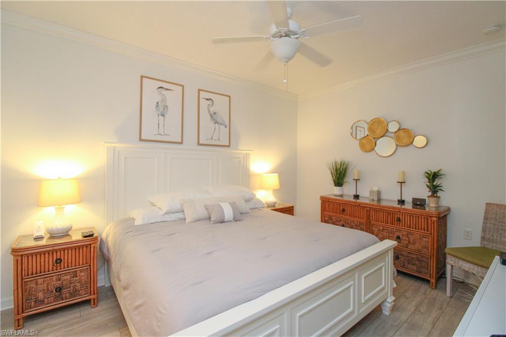 9554 Trevi Court, Unit 4737 Naples, FL 34113 - Photo 14 of 49 a bedroom with a bed and a chandelier