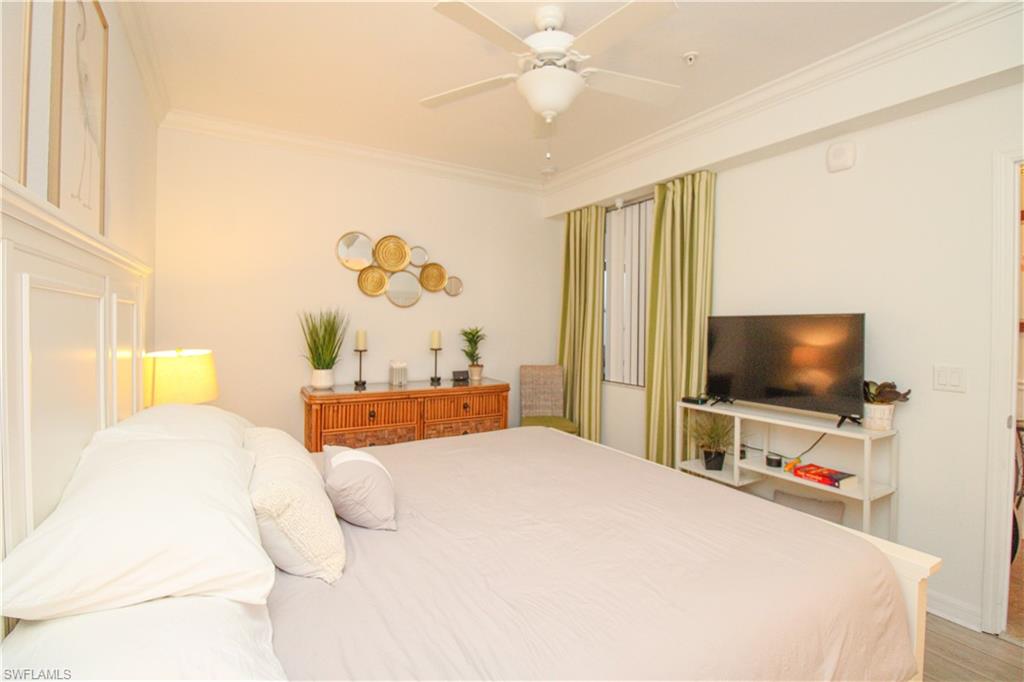 9554 Trevi Court, Unit 4737 Naples, FL 34113 - Photo 16 of 49 a bedroom with a bed and a flat screen tv