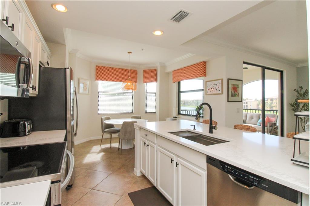 9554 Trevi Court, Unit 4737 Naples, FL 34113 - Photo 24 of 49 a kitchen with counter top space a sink and a refrigerator