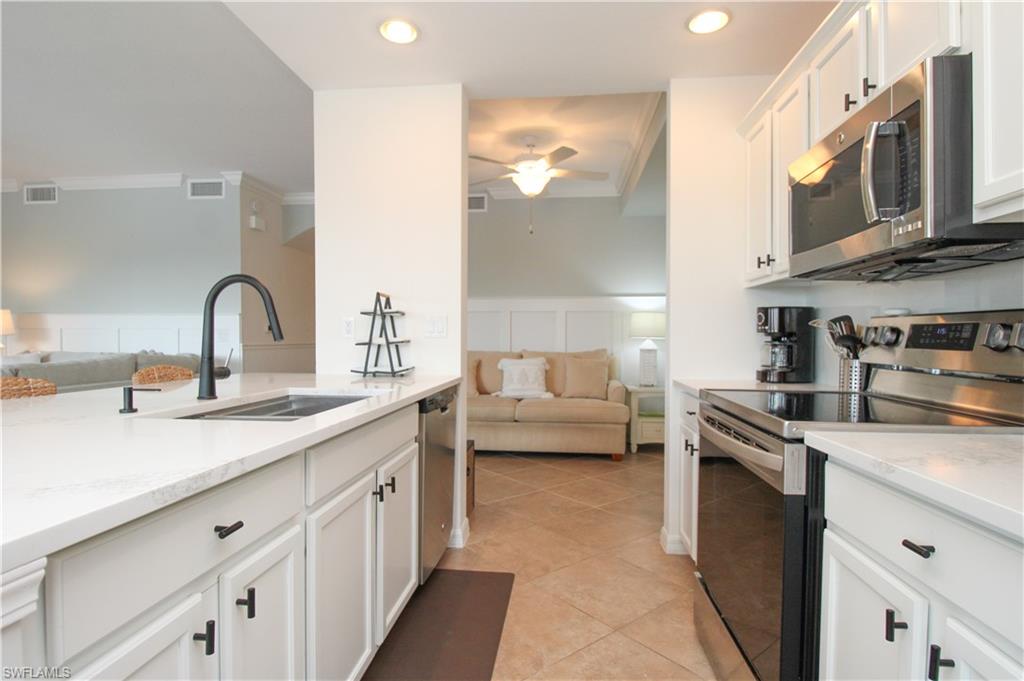 9554 Trevi Court, Unit 4737 Naples, FL 34113 - Photo 28 of 49 a kitchen with stainless steel appliances granite countertop a sink and cabinets