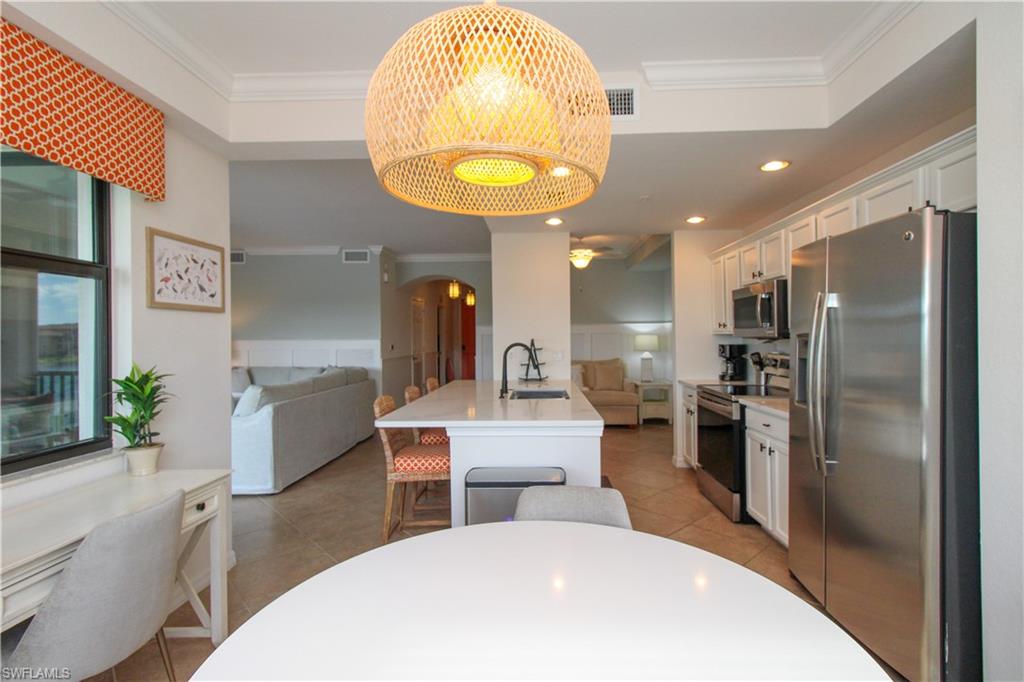 9554 Trevi Court, Unit 4737 Naples, FL 34113 - Photo 29 of 49 a living room with stainless steel appliances furniture a chandelier and a kitchen view