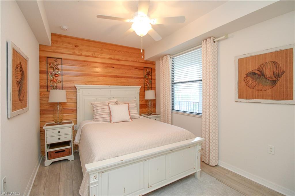 9554 Trevi Court, Unit 4737 Naples, FL 34113 - Photo 10 of 49 a bedroom with a bed and a chandelier