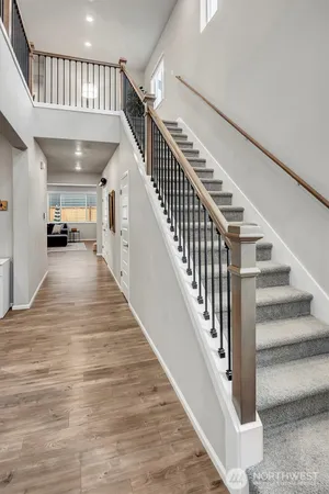 a view of staircase with lots of frames on wall and wooden floor