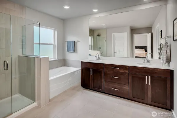 a bathroom with a tub sink and mirror