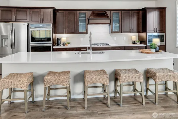 a kitchen with granite countertop white cabinets and stainless steel appliances