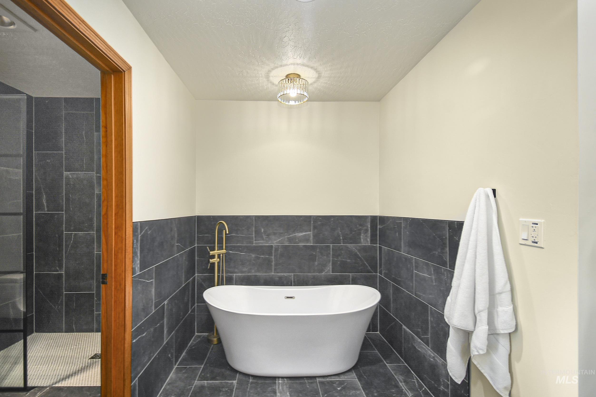127 Ruth Lane Nampa, ID 83686 - Photo 29 of 49 Dual vanity featuring dark green cabinetry, white countertops, and gold-finish fixtures