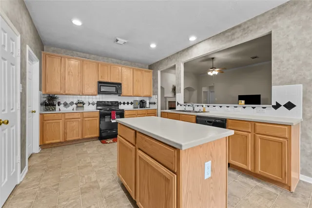 a kitchen with stainless steel appliances kitchen island granite countertop a stove a sink a refrigerator and a refrigerator