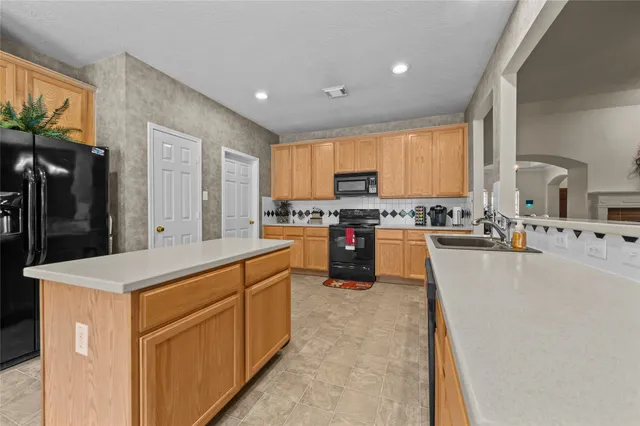 a large kitchen with a stove a sink a dining table and chairs