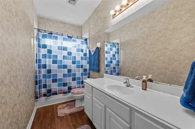 a bathroom with a double vanity sink toilet and shower
