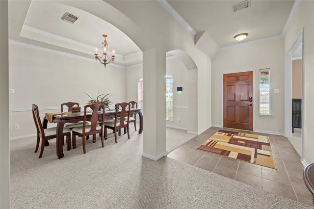 a view of a dining room with furniture and a chandelier
