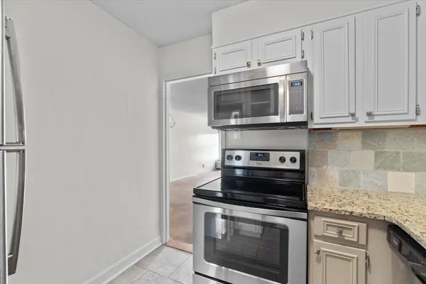 a kitchen with cabinets stainless steel appliances and a counter top space