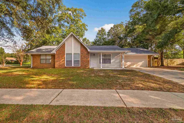 a view of a yard in front of a house with a large tree