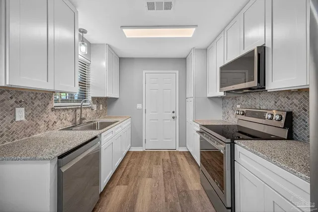 a kitchen with a sink stove microwave and cabinets