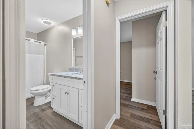a bathroom with a granite countertop toilet a sink and a mirror