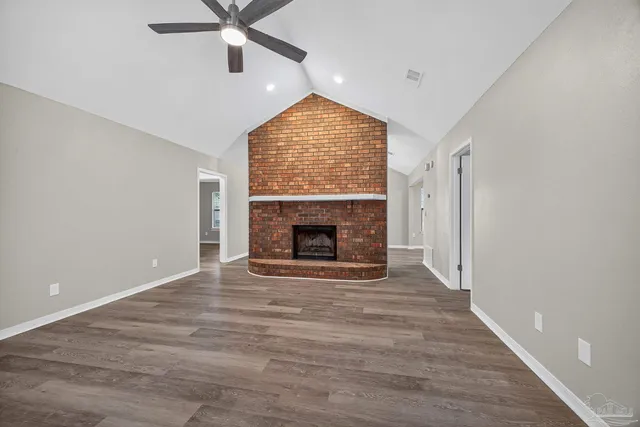 a view of empty room with wooden floor and fireplace