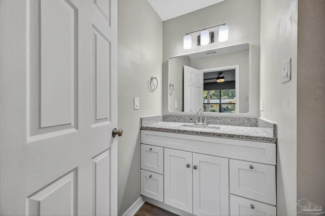 a bathroom with a granite countertop sink and a mirror