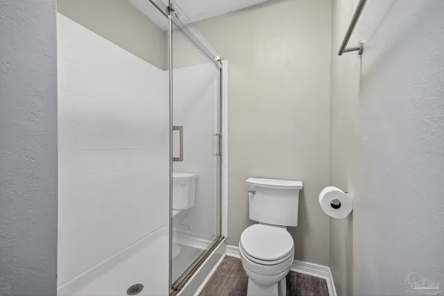 a bathroom with a toilet and a shower