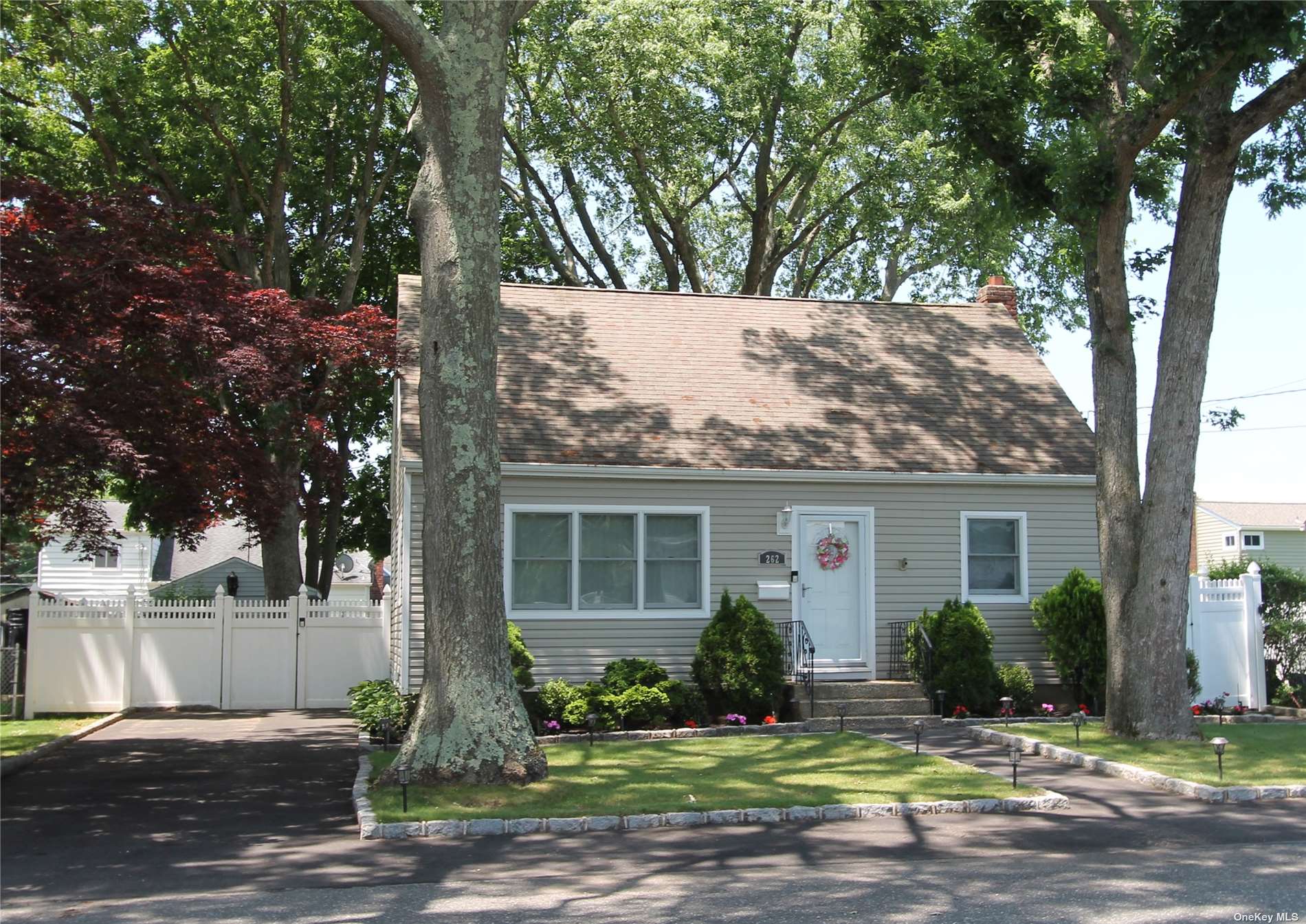 a front view of a house with a yard and tree s