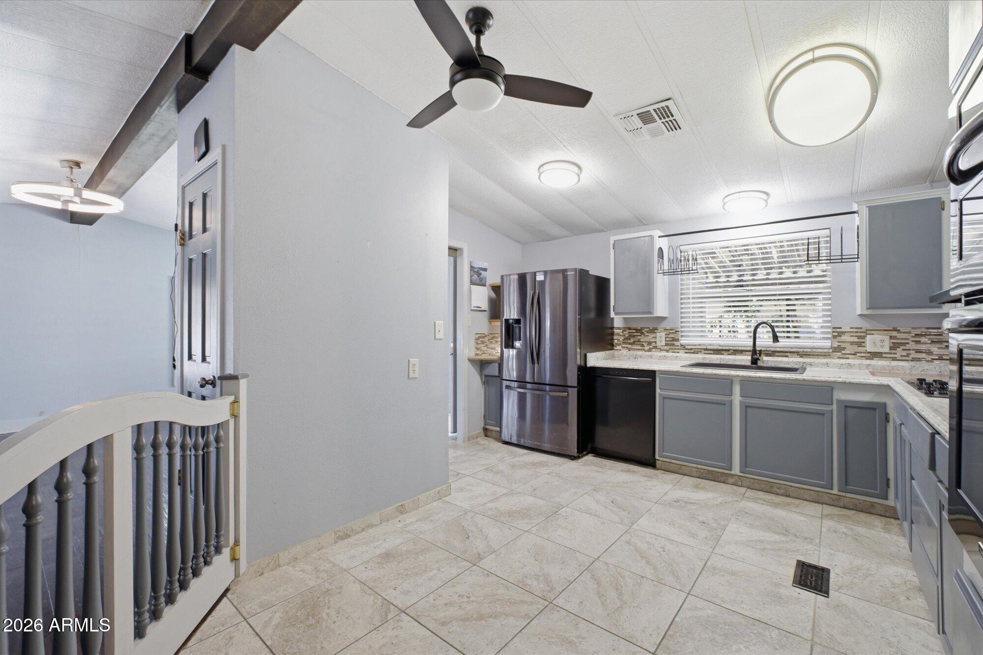 205 South Higley Road, Unit 183 Mesa, AZ 85206 - Photo 11 of 30 a kitchen with stainless steel appliances granite countertop a refrigerator and a sink