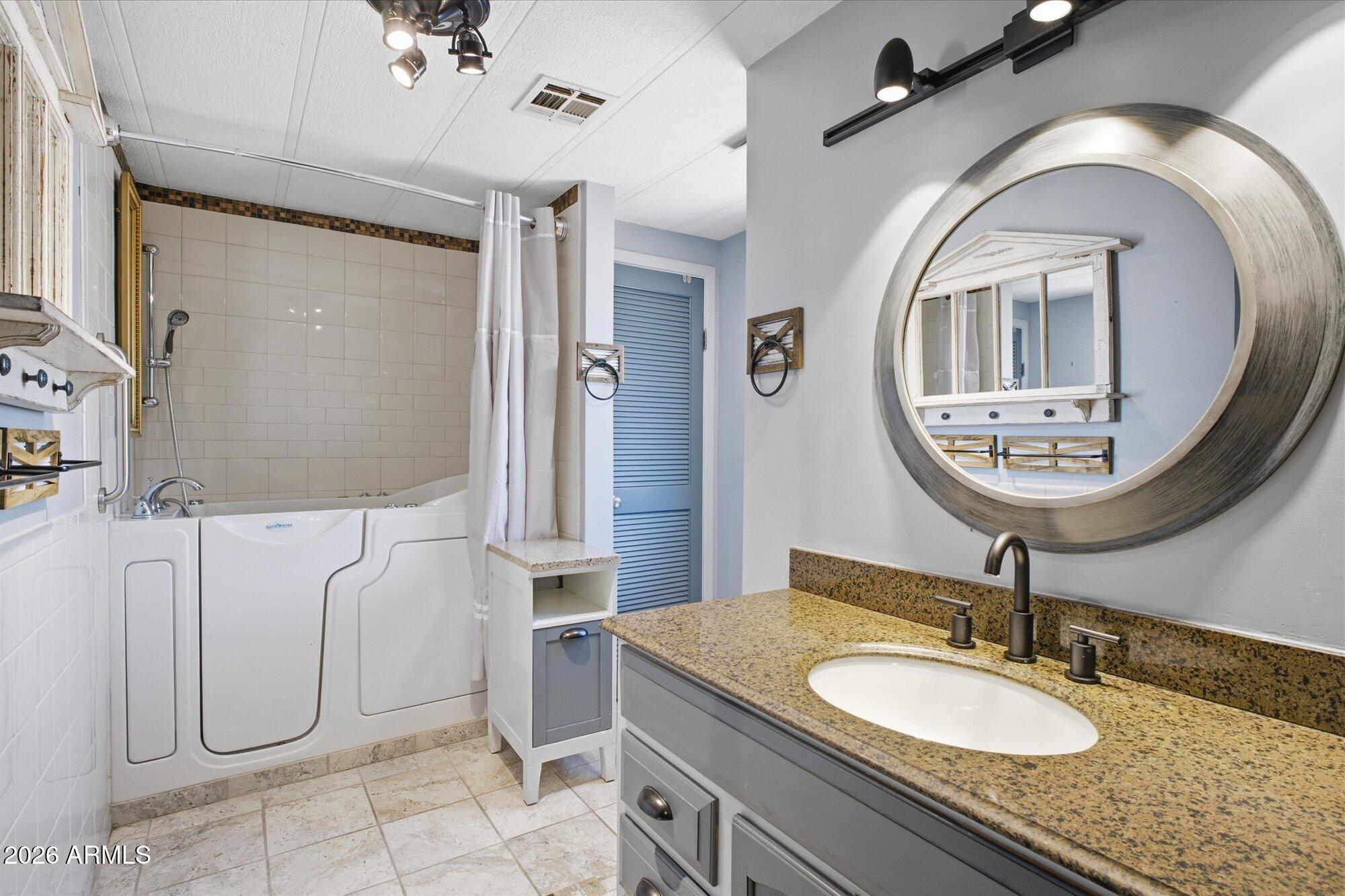 205 South Higley Road, Unit 183 Mesa, AZ 85206 - Photo 14 of 30 a bathroom with a granite countertop toilet sink and mirror