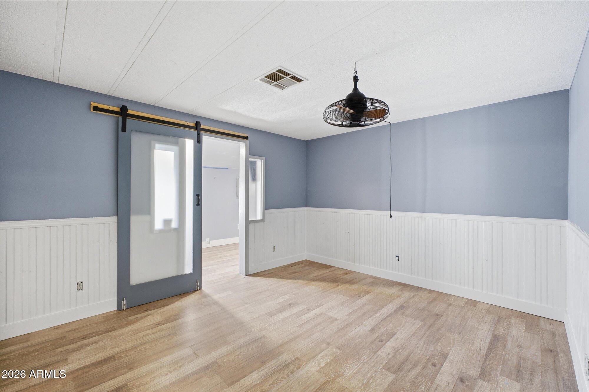205 South Higley Road, Unit 183 Mesa, AZ 85206 - Photo 19 of 30 a view of an empty room with wooden floor and windows