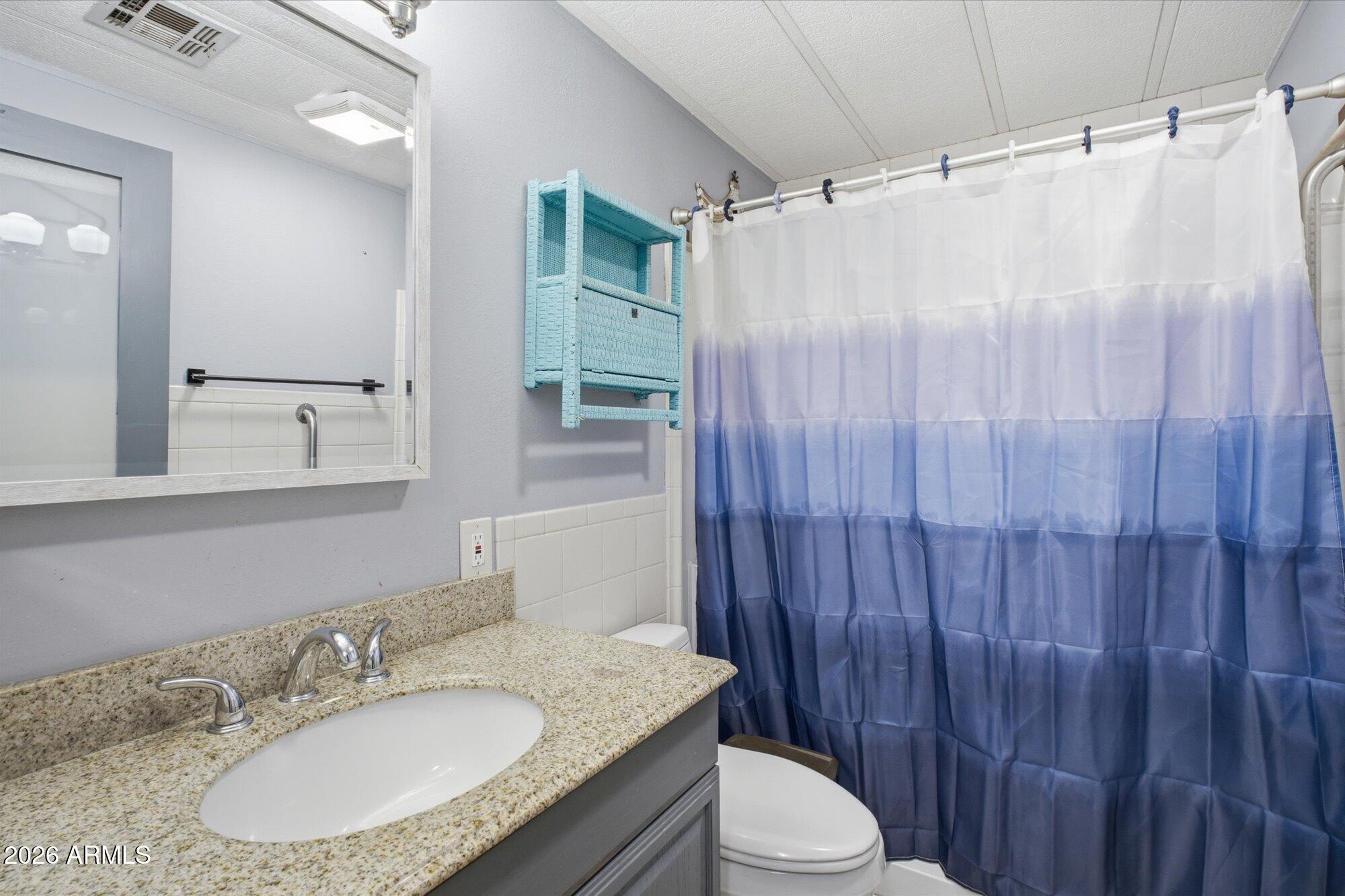 205 South Higley Road, Unit 183 Mesa, AZ 85206 - Photo 21 of 30 a bathroom with a granite countertop sink toilet and shower