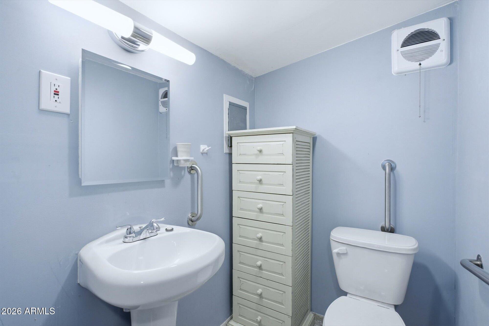 205 South Higley Road, Unit 183 Mesa, AZ 85206 - Photo 22 of 30 a bathroom with a toilet sink and a mirror