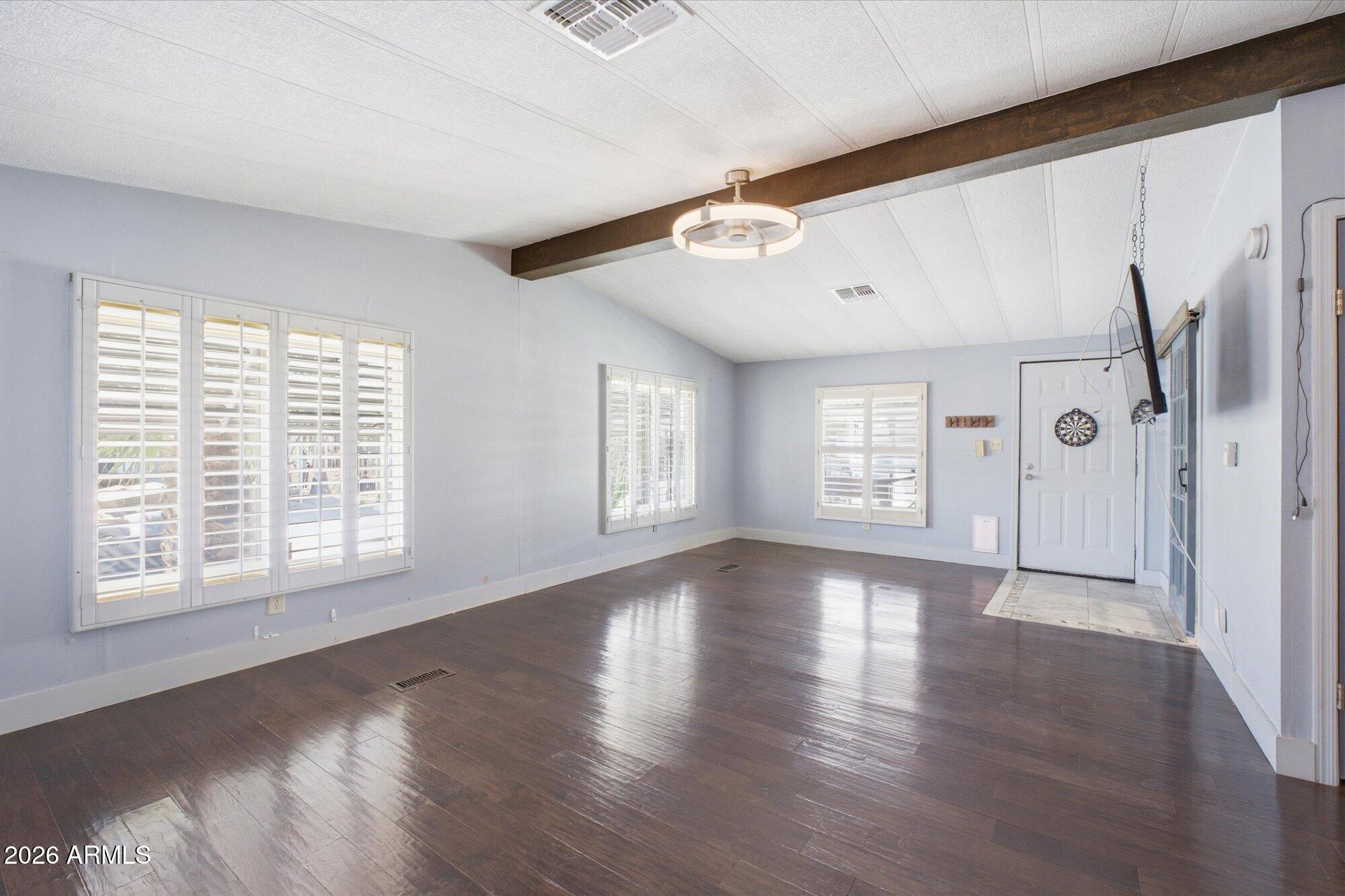 205 South Higley Road, Unit 183 Mesa, AZ 85206 - Photo 3 of 30 a view of an empty room with wooden floor and a window