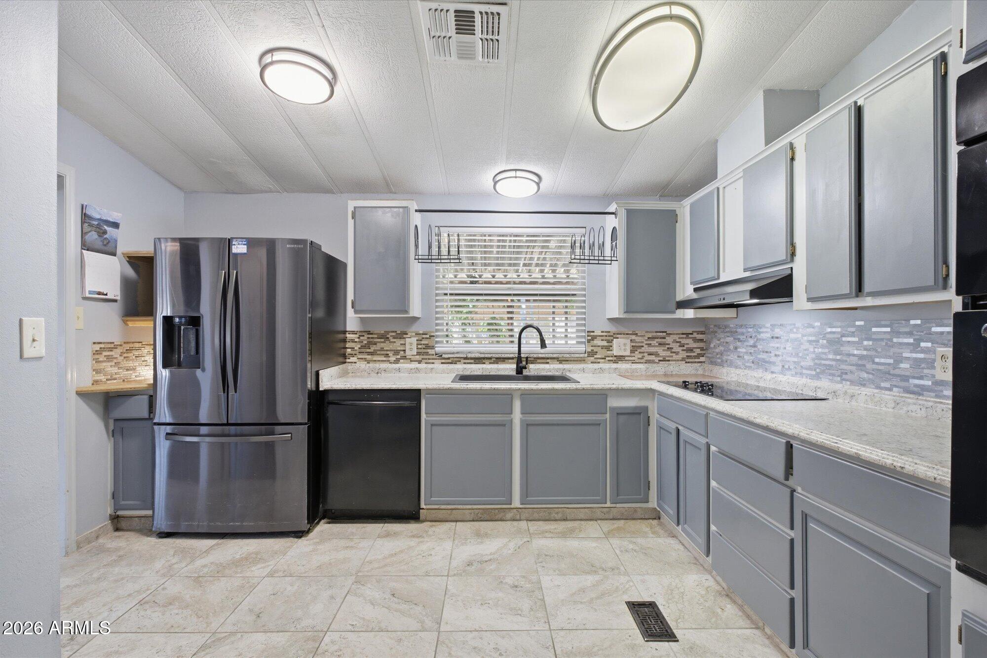 205 South Higley Road, Unit 183 Mesa, AZ 85206 - Photo 4 of 30 a kitchen with stainless steel appliances granite countertop a refrigerator sink and cabinets