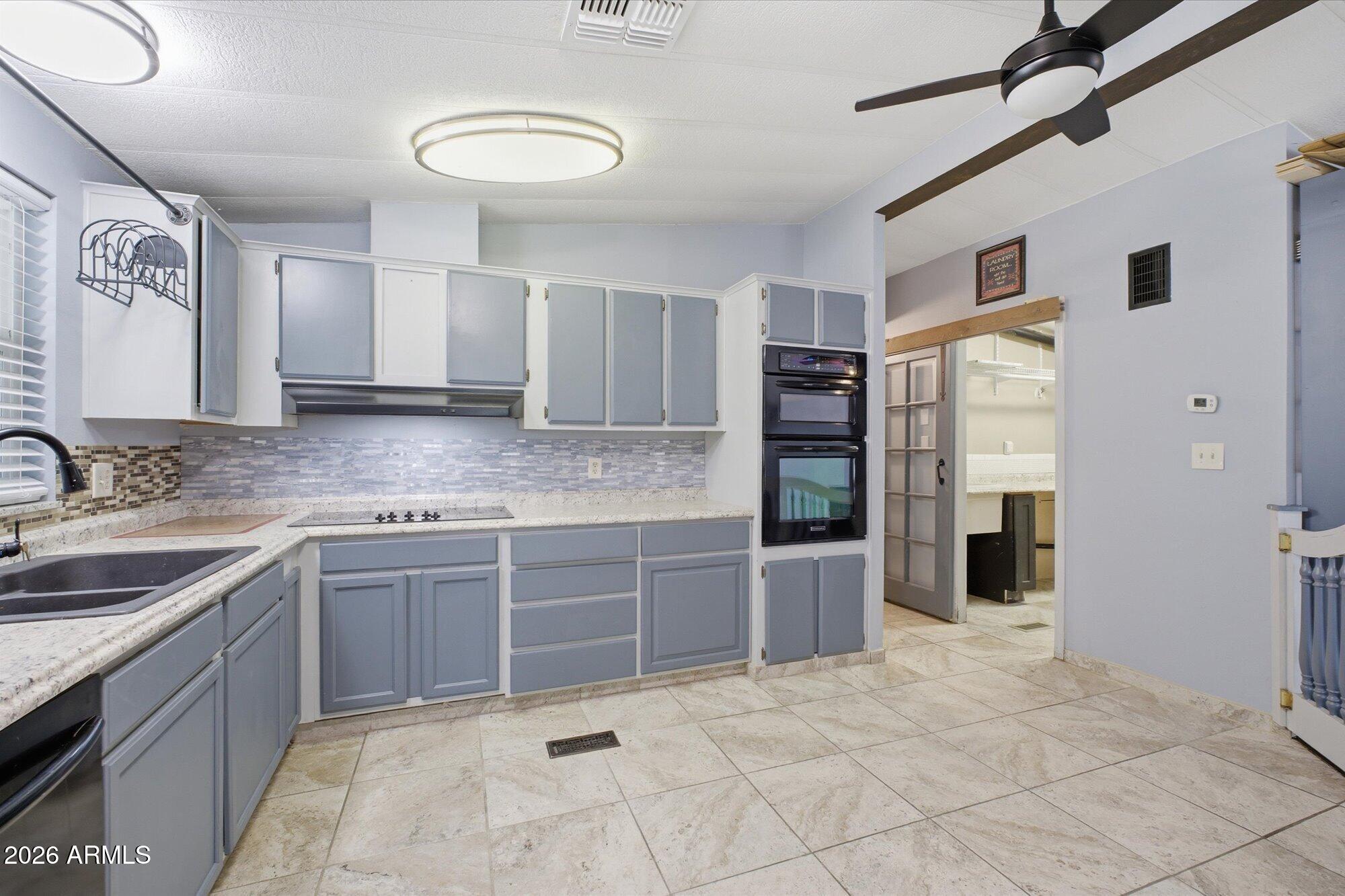 205 South Higley Road, Unit 183 Mesa, AZ 85206 - Photo 10 of 30 a large kitchen with stainless steel appliances granite countertop a refrigerator and a sink