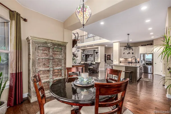 a dining room with furniture a chandelier and wooden floor