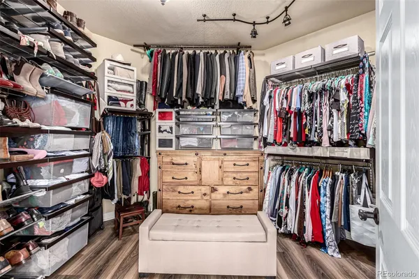 a view of walk in closet with clothes and shoes