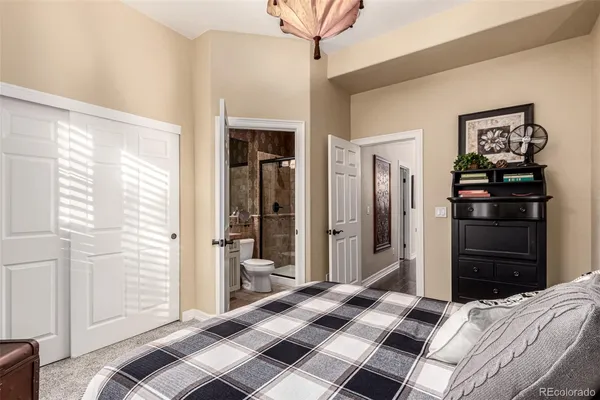 a bedroom with a bed and a refrigerator