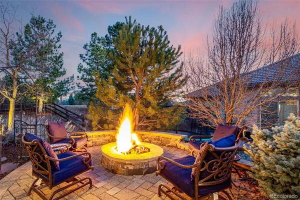 a backyard of a house with fire pit and outdoor seating