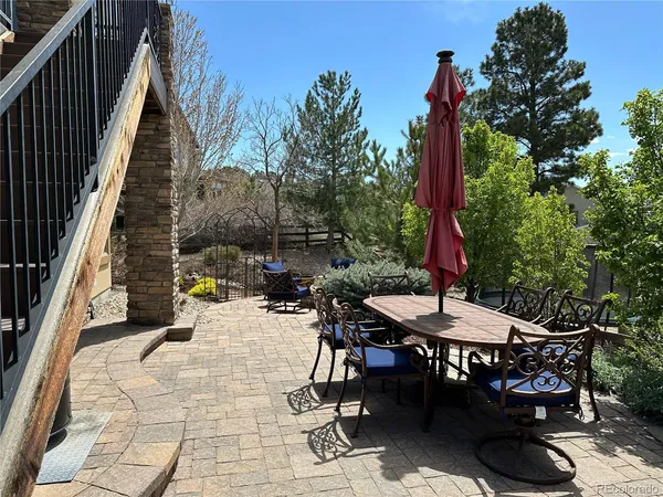 a patio with table and chairs and potted plants