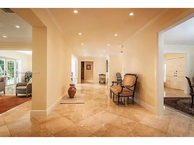 a kitchen with stainless steel appliances kitchen island granite countertop a table chairs sink and cabinets