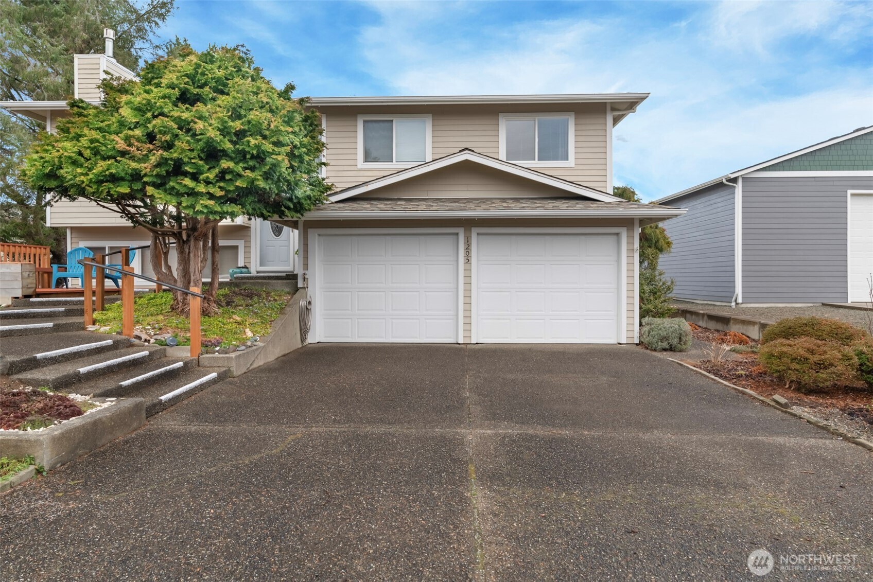 1205 195th Street Long Beach, WA 98631 - Photo 2 of 36 a front view of a house with a yard and garage