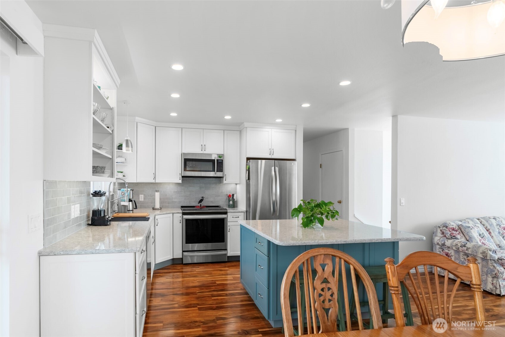 1205 195th Street Long Beach, WA 98631 - Photo 10 of 36 a kitchen with stainless steel appliances granite countertop a refrigerator a stove a sink dishwasher and a dining table with wooden floor