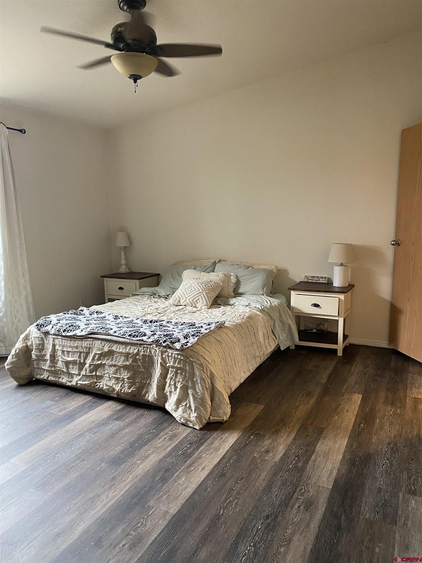 7156 Peach Valley Road Delta, CO 81416 - Photo 22 of 33 a bedroom with a bed and wooden floor