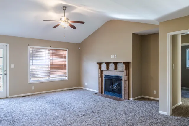 a view of empty room with fireplace and fan