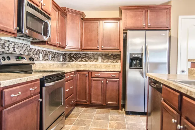 a kitchen with a refrigerator a sink and cabinets
